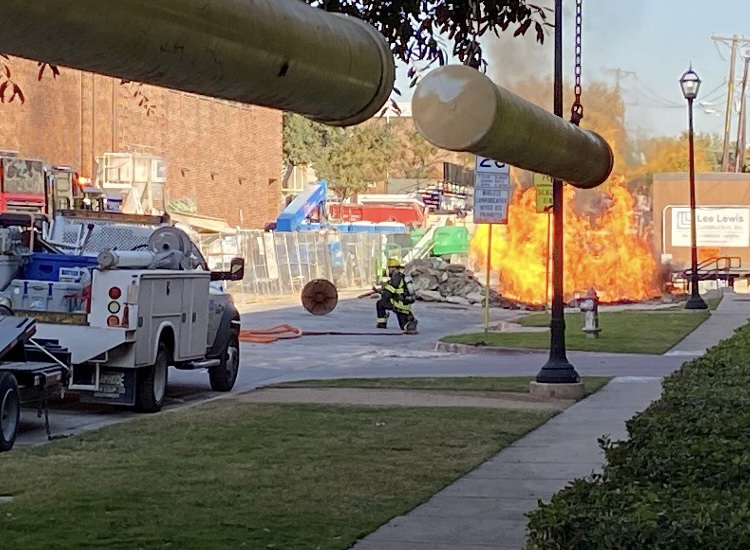 After a gas line explosion, a fire burns in the street near the Westchester entrance of the parking garage. The fire sent two Atmos workers to Parkland Hospital, and it occurred a day after students and staff were evacuated from the building.