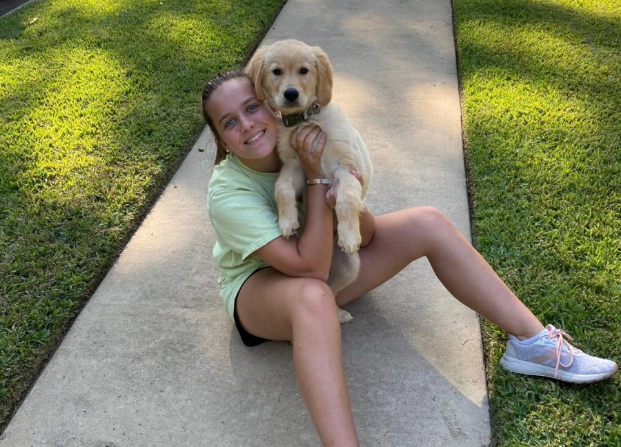 Sophomore Emily Bailey poses for a picture with her new puppy, Buck. Her family recently adopted Buck during the quarantine. We all take care of him, Bailey says.