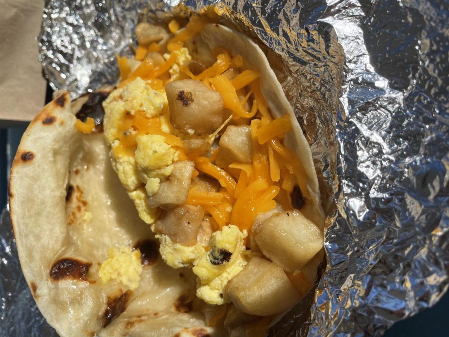 Contents of a breakfast taco from Rusty Taco spill out of the tortilla. Rusty Taco serves breakfast tacos all day long.