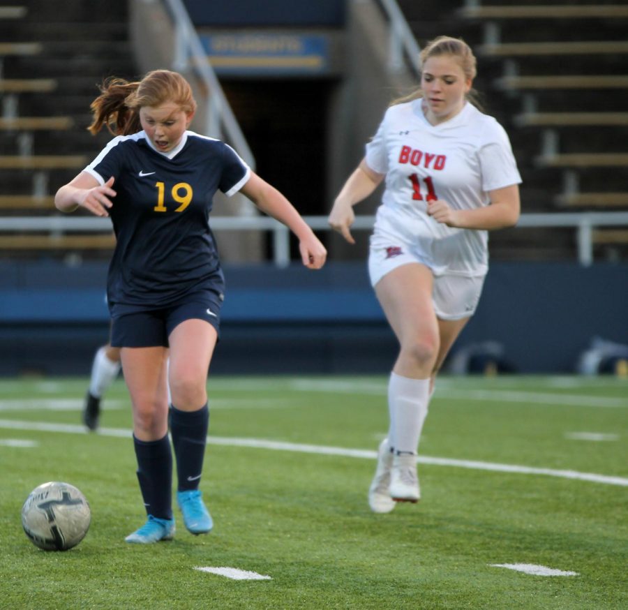 Freshman Lauren Ridgway sprints to get to the ball before players from McKinney Boyd. Ridgway passed to her teammates to get around the other team.
