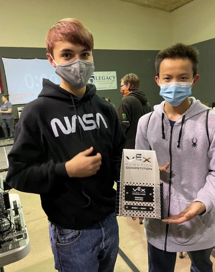 Juniors Jed Graham and James Peng hold up their design award after demonstrating superior process design knowledge. In the VEX Robotics Competition,  teams of students are tasked with building a robot to play against other teams in a game-based engineering challenge. 