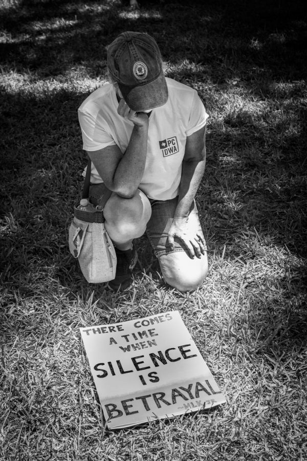 A high school parent kneels with her sign during an 8 minute moment of silence in honor of George Floyd. When Floyds death sparked nationwide protests in honor of the Black Lives Matter movement, Park Cities residents held local events. Shortly after, a group of students crafted a video titled Dear Highland Park to raise awareness of racial issues in the school district. 