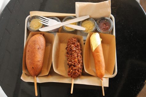 The Pickle (left), the Bacon (middle), and the Corn Dog Queen (right) sit on the tray with multiple containers of mustard and ketchup. The Pickle contained a juicy pickle with the meat inside the pickle. The Bacon contained a pork sausage infused with jalapeno and cheddar cheese. The Corn Dog Queen was very similar to the Classic, but the only difference was the piece of 24K gold on the tip.