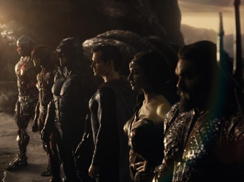 Ray Fisher (Cyborg), Ezra Miller (The Flash), Ben Affleck (Batman), Henry Cavill (Superman), Gal Gadot (Diana Prince), and Jason Momoa (Aquaman) all pose for group shot looking in the distance. 