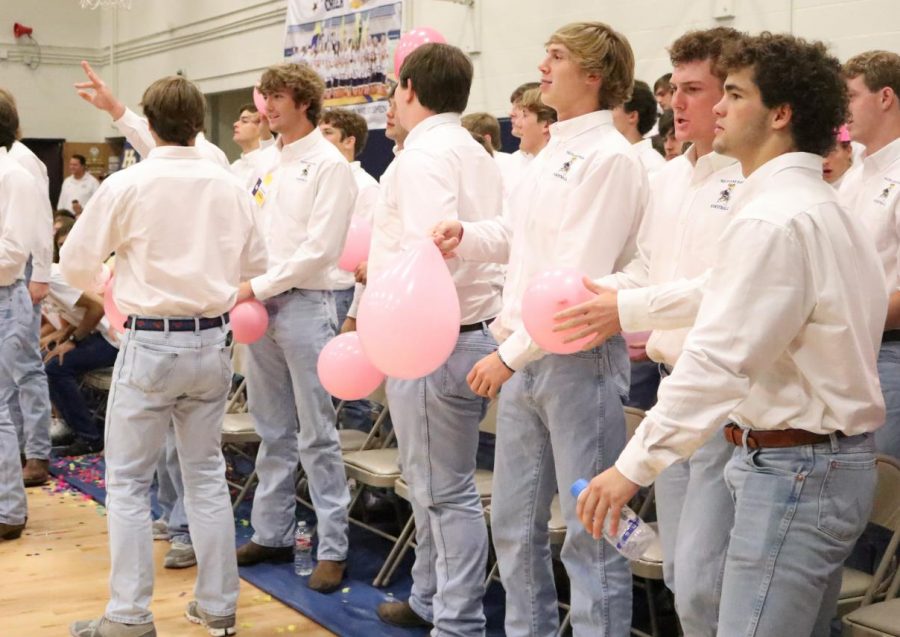 The varsity football team prepares for team time during a pep rally. 