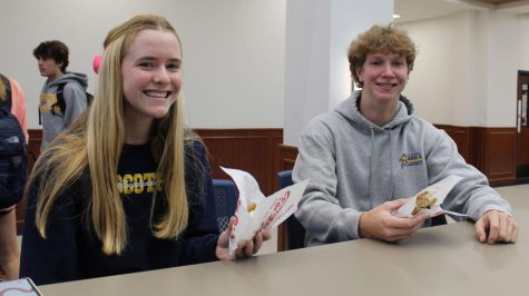 Despite food shortages in the cafeteria, junior Julia Yates and senior Drake McCauley enjoy Pokey Os ice cream sandwiches during lunch. Although there are shortages in the cafeteria lines, students have been able consistently to eat foods that come from name-brand companies. With the lines being long in the cafeteria, its fun having a treat once in a while, Yates said.