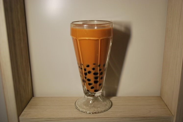 Freshly mixed Thai eggnog boba tea awaits for someone to take a sip and relax on their holiday.   The drink originated from a successful experimentation with combining different drinks in the fridge.