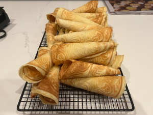 Freshly baked Krumkake cools, waiting to be filled. The cookies, which resemble waffle cones, have a rich history in Norwegian holiday festivities.