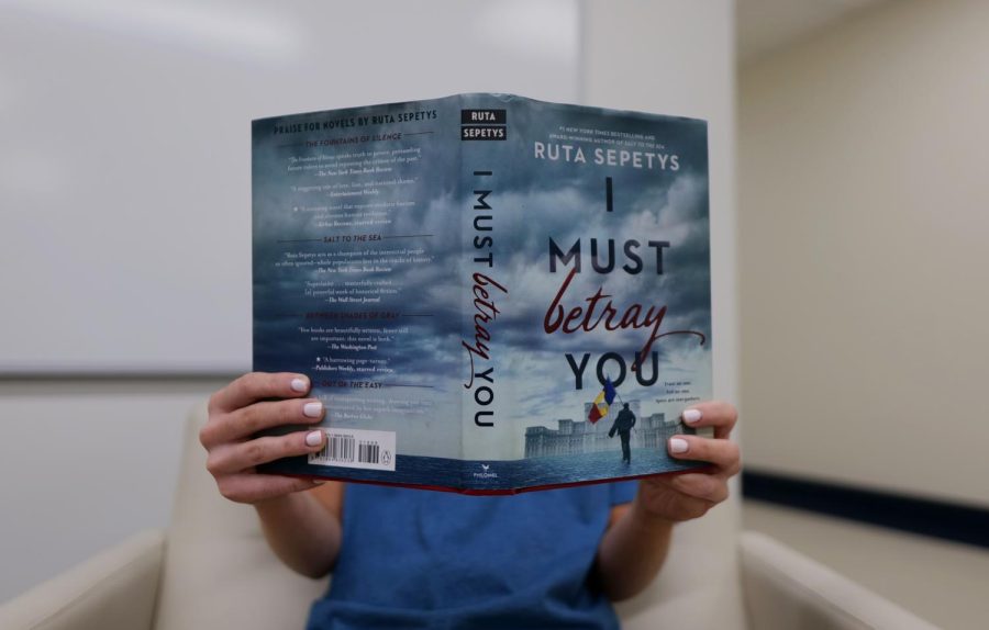 Junior C.C. Huthnance reads Ruta Sepetys’ book I Must Betray You in the library. I Must Betray You is Sepetys’ most recent release and was announced back in October. I Must Betray You captivates its audience by through worldbuilding and strong relationships between characters.