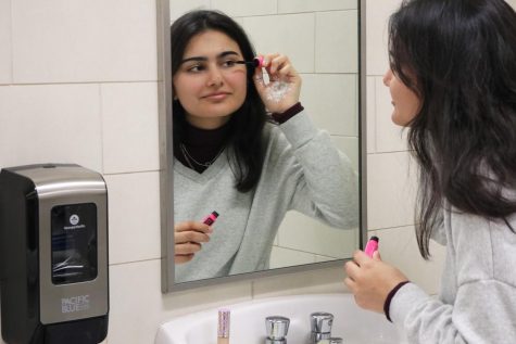 With the help of a mirror, junior Zainab Shah applies makeup while sophomores Era Johnson and Ava Robertson look on. Shah argues modern-day beauty standards are unattainable and feel it’s important to look beyond surface-level beauty. “A healthier way to feel beautiful is to recognize yourself as an individual and all your unique physical characteristics,” Shah said.