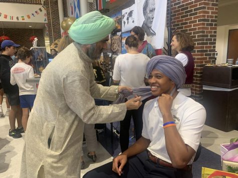 Parent Sandeep Singh wraps a turban around senior Carter Morelands head. Singhs stand at culture fest showcased Indian culture as well as Sikhism. [Showcasing culture] takes the stigma away, when people understand Indians and Sikhism people get along better, Singh said. 
