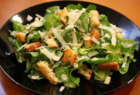 The caesar salad once its been prepared and ready to serve. The croutons add a crunch that blends well with the parmesan in the dressing.