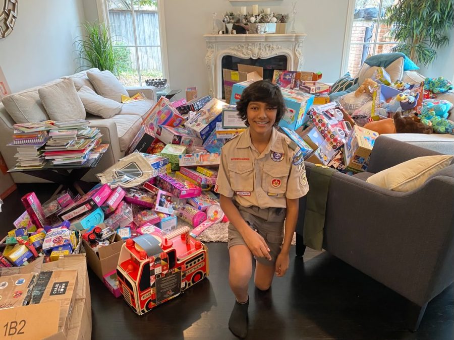After collecting completing the toy drive, freshman Dev Shah poses with the donations.  Shah collected the largest amount of donations during the 2022 Christmas season. I love how the community was so willing to give, Shah said. 