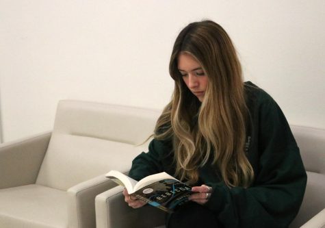 Junior Allie Rose Olmstead reads a book for her English class. She moved to the district from Tulsa, Oklahoma where she attended a small private school. I was intimidated to come a big public school, Olmstead said.