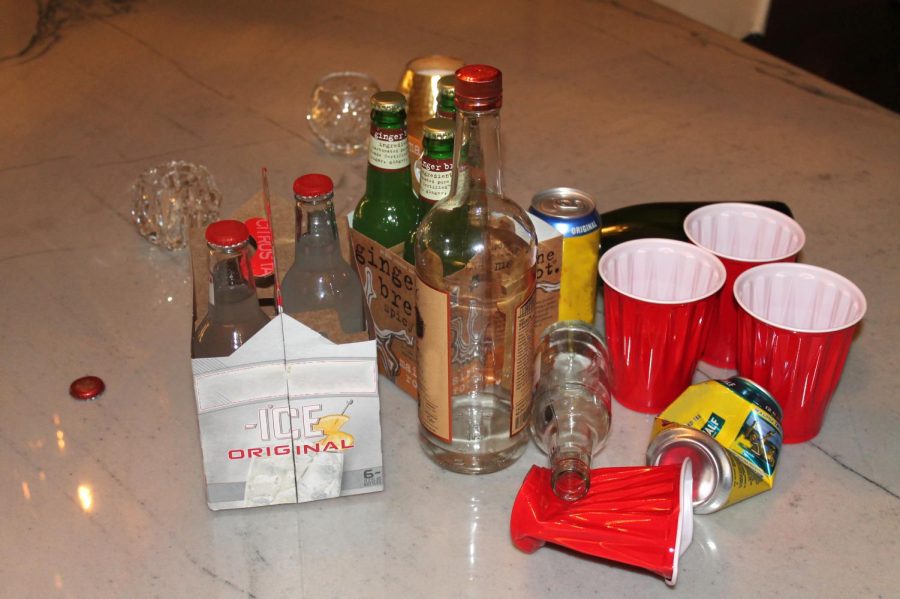 A pile of empty beer cans and bottles lay spread out on a table. Scenes like this are not uncommon at parties where the majority of people drinking are under 21.