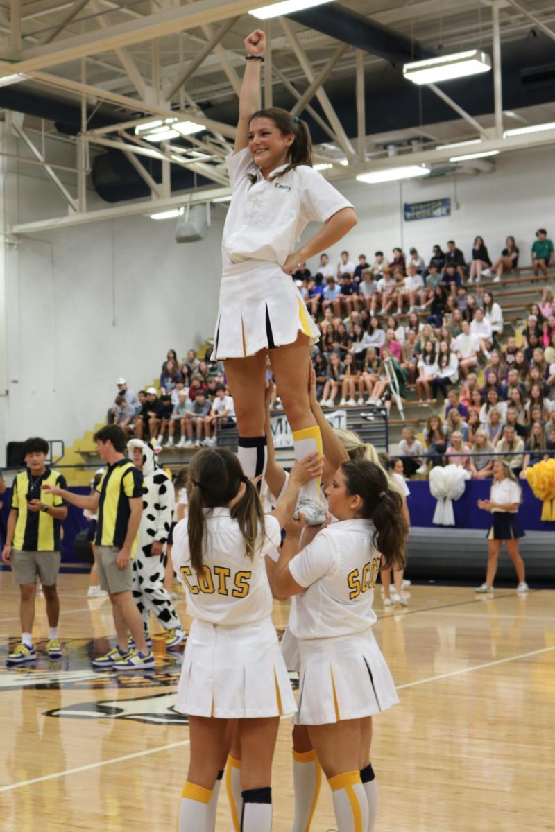 Cheerleader Emery Beichler poses at the top of the cheer pyramid mid-performance.