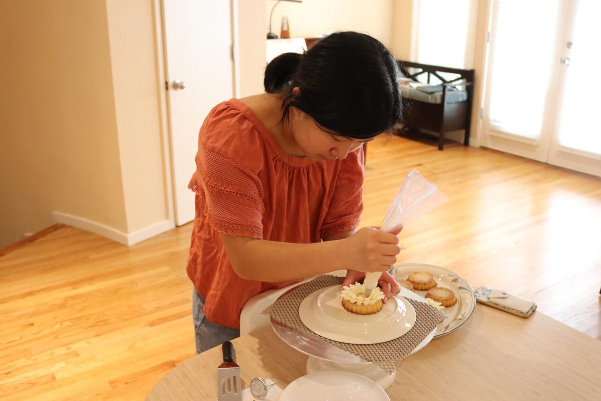 Son practices piping with Swiss meringue buttercream frosting.